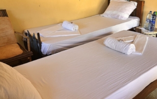 2 single beds in affordable comfort budget rooms with beds made of recycled wood of boats.